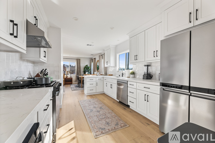 A modern kitchen with stainless steel appliances and white cabinets.