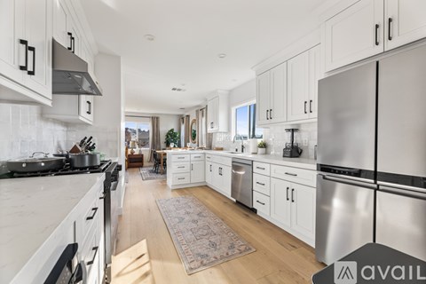 A modern kitchen with stainless steel appliances and white cabinets.