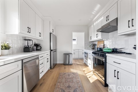 A kitchen with white cabinets and appliances.
