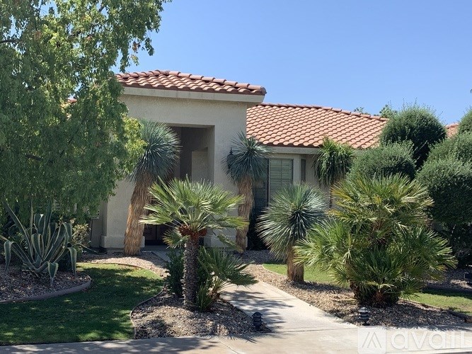 A house with a red tile roof and a garden in front.