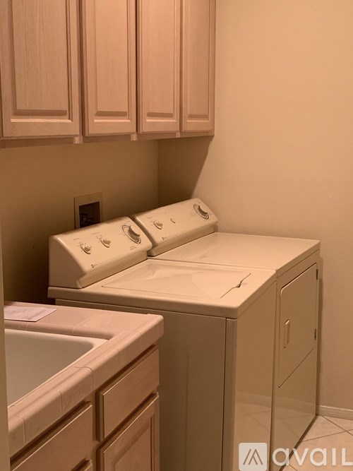 A white washing machine and dryer in a laundry room.