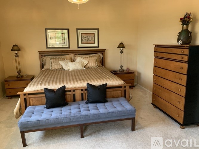 A bedroom with a bed, nightstands, and a bench.