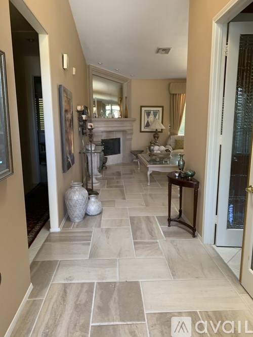 A hallway with a stone floor and a fireplace.
