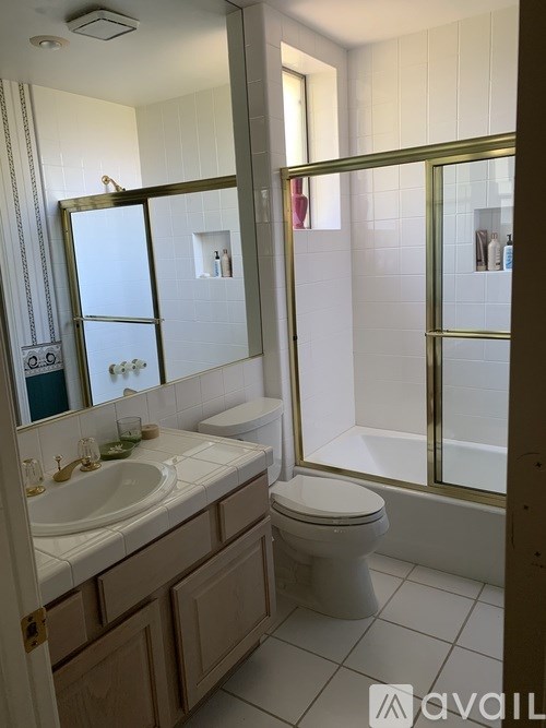 A bathroom with a toilet, sink, and mirror.