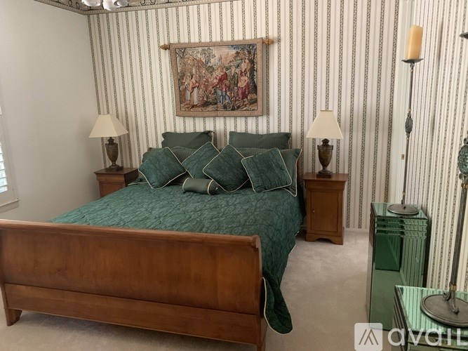 A bedroom with a bed, nightstands, and a painting on the wall.