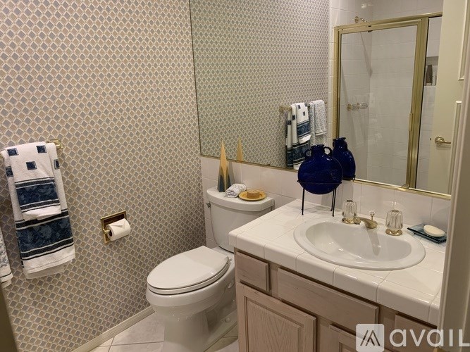 A bathroom with a toilet, sink, and mirror.