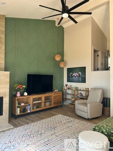 A living room with a green wall and a fireplace.