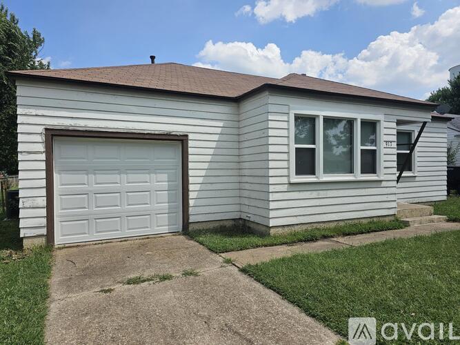 A house with a garage door and a window is for sale.