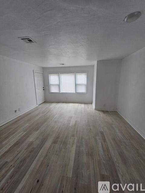 A room with wooden flooring and a door.