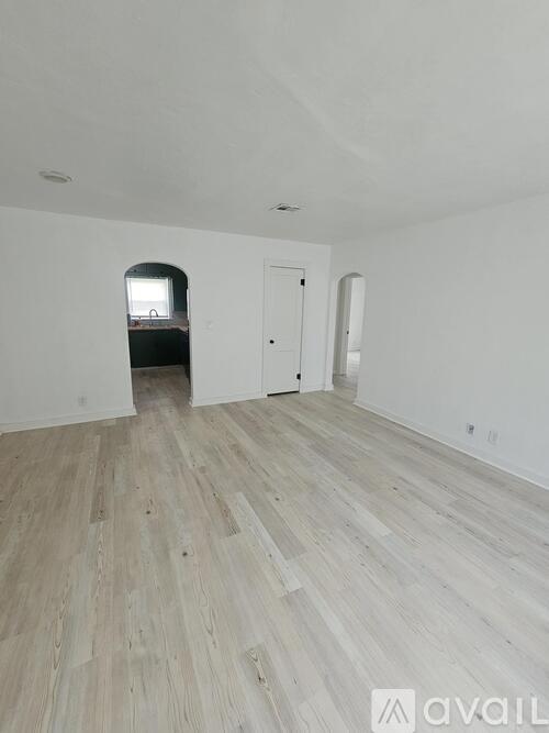 A room with wooden flooring and a white door.