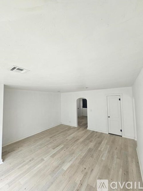 A room with wooden flooring and white walls.