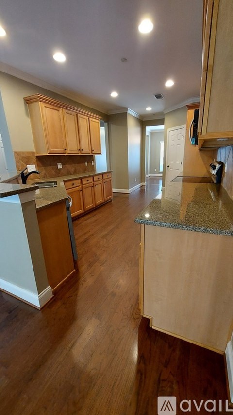 A kitchen with wooden cabinets and a granite countertop.