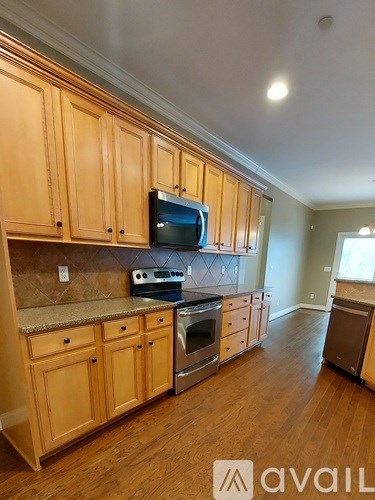 A kitchen with wooden cabinets and a granite countertop.