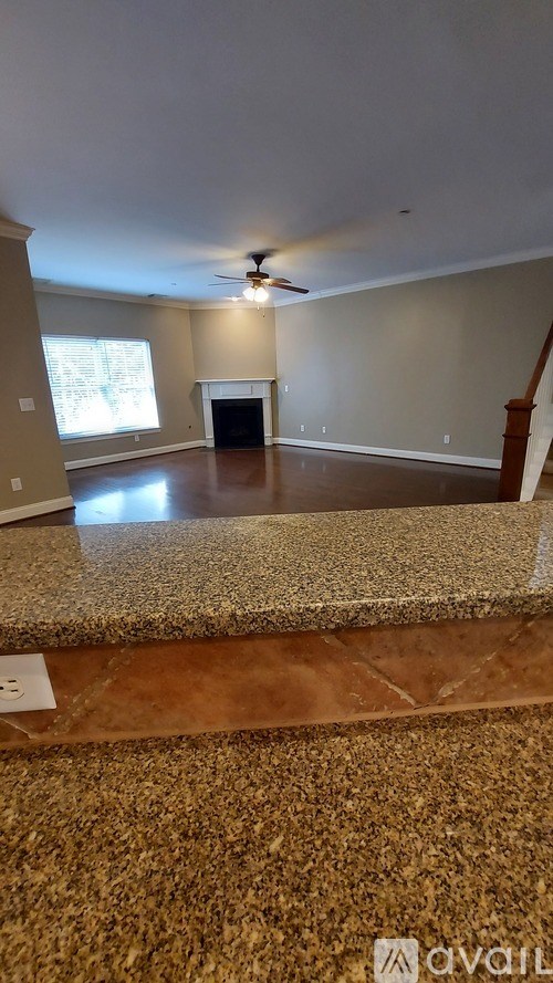A living room with a fireplace and a ceiling fan.