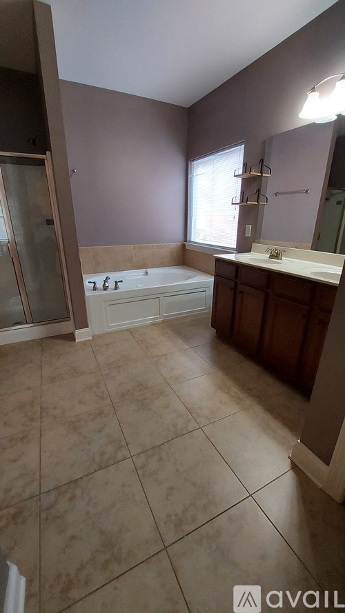 A bathroom with a tiled floor and a bathtub.