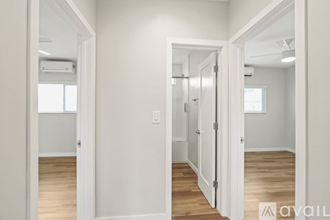 A white door is open to a room with wooden floors.