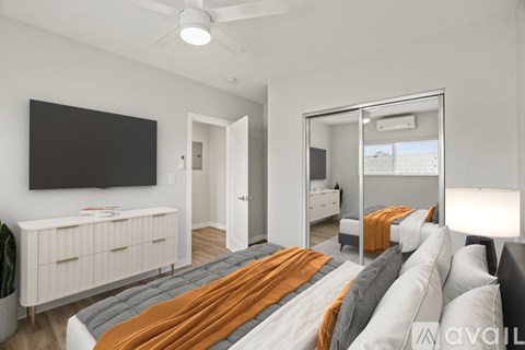 A bedroom with a bed, dresser, and mirror.