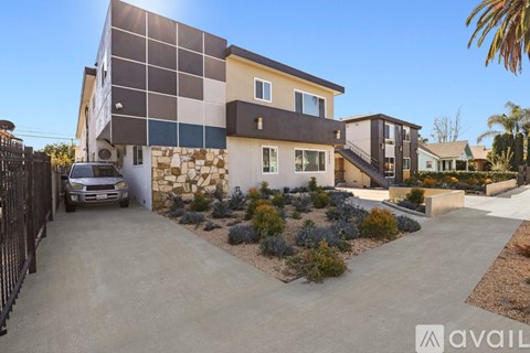 A modern house with a driveway and a car parked in front.