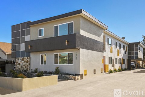 A modern house with a flat roof and a large front yard.