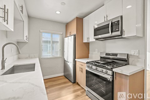 A kitchen with a stainless steel refrigerator, oven, and microwave.