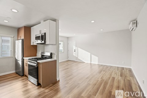 A kitchen with wooden floors and a refrigerator.