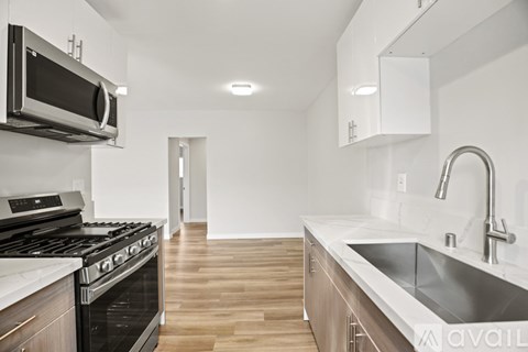 A modern kitchen with a stove, microwave, and sink.