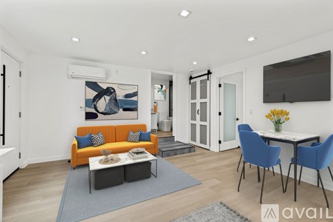 A living room with a sofa, chairs, and a painting on the wall.