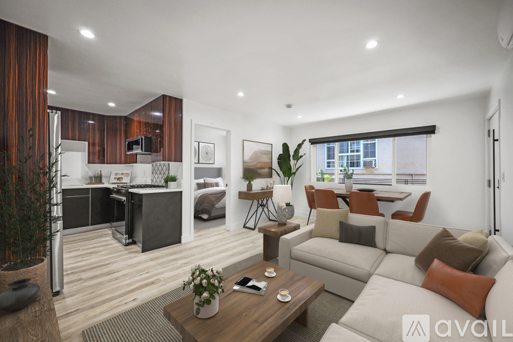 A modern living room with a kitchen area in the background.
