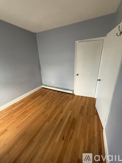 A room with wooden flooring and a white door.