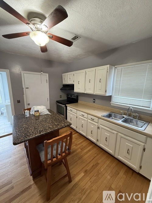 A kitchen with a table and chairs.