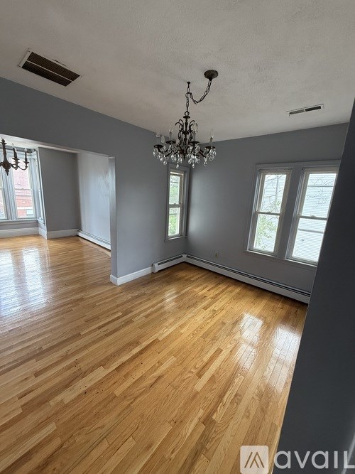 A room with wooden floors and a chandelier.