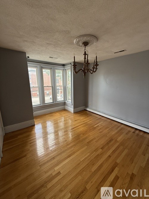 A room with wooden floors and a chandelier.