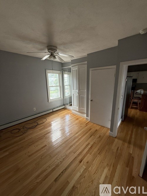 A room with wooden flooring and a ceiling fan.