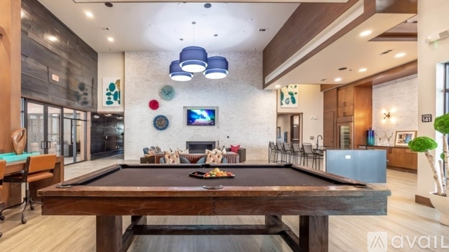 A billiard table is in the middle of a room with a TV and a fireplace.