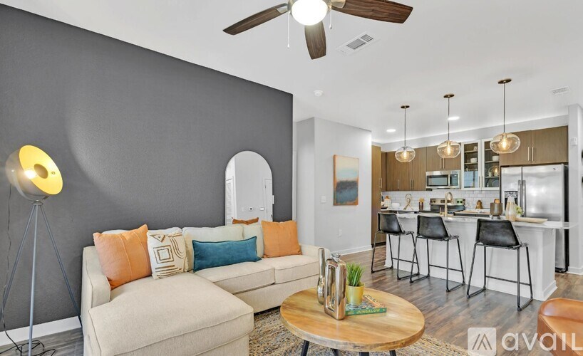 A living room with a grey wall and a white couch.