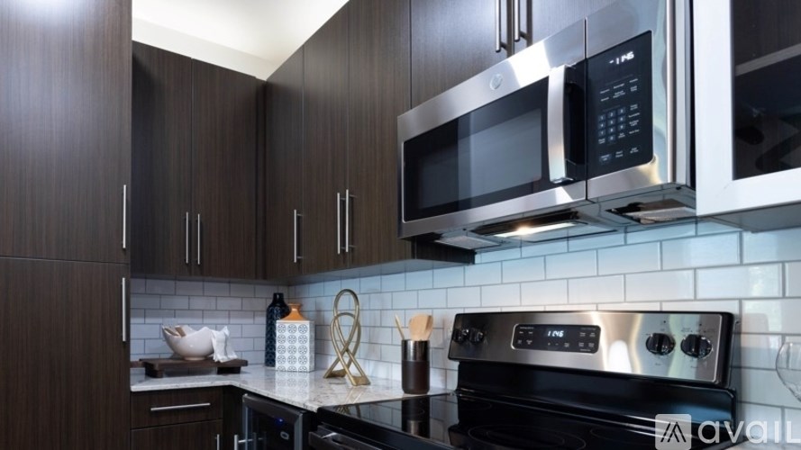 A kitchen with a black stove top oven and a black microwave above it.