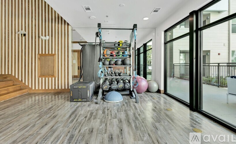 A room with a wooden floor and a gym equipment set up.