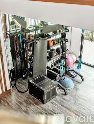 A gym with a variety of equipment including a treadmill, weights, and resistance bands.