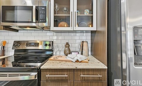 A modern kitchen with a black stove top oven and a microwave above it.