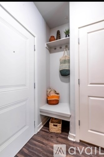 A small white closet with a shelf and a hanging bag.