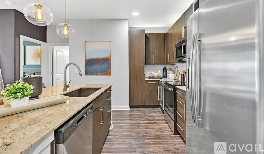 A modern kitchen with a stainless steel refrigerator and wooden cabinets.