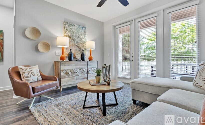 A living room with a brown leather chair, a wooden coffee table, and a white sofa.