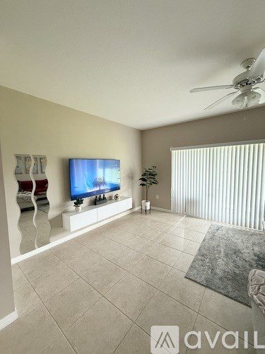 A living room with a television and a plant.