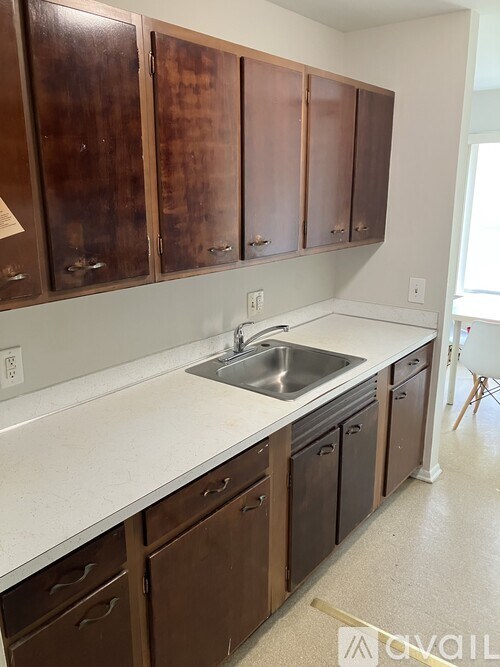 Brown cabinets with a white sink and counter.