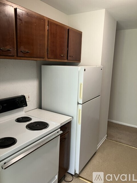 A kitchen with a white fridge and stove top oven.