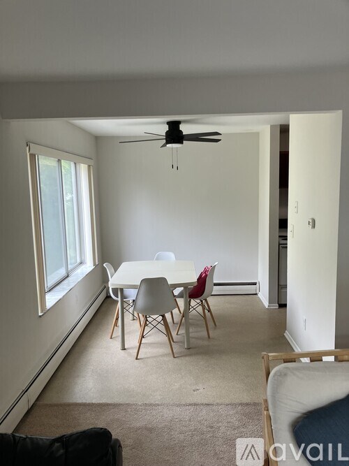 A room with a table and chairs and a fan.