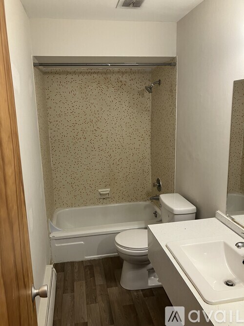 A bathroom with a white toilet, a bathtub, and a sink.