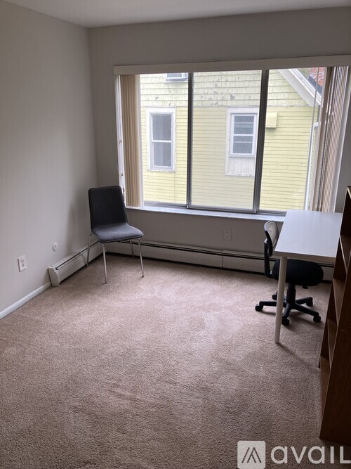 A room with a window, a desk, and a chair.