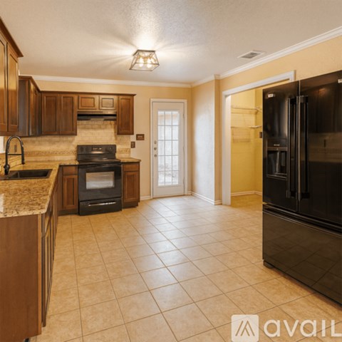 A kitchen with a black refrigerator and a black oven.