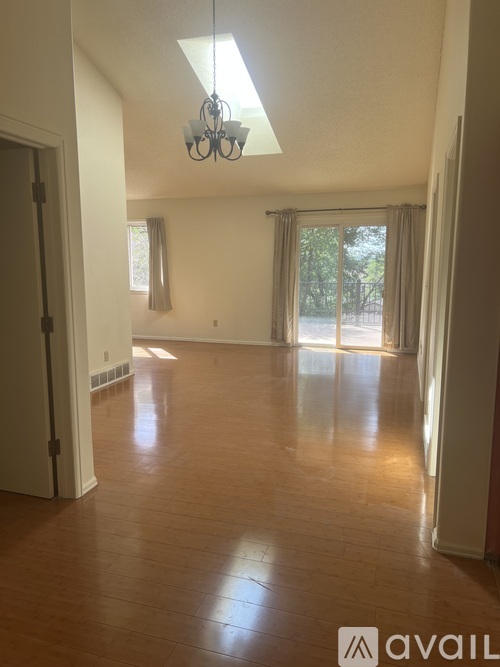A room with wooden floors and a chandelier.